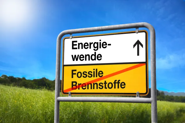 Blick auf ein Straßenschild mit der Aufschrift "Energiewende" oben und unten, durchgestrichen "Fossile Brennstoffe" 